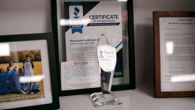 2023 BBB Torch Awards glass trophy and placard for Maryland, proudly showcased on an office mantle