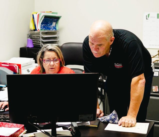 Clint Jones, owner of Services Unlimited, and his office manager review HVAC proposals on the OnCall Air dashboard